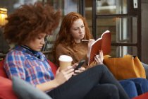 Female friends relaxing in coffee shop — Stock Photo
