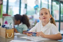 Schoolgirl looking up in classroom lesson at primary school — Stock Photo