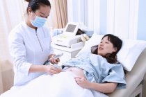 Sonografo che esegue la scansione ecografica della paziente incinta — Foto stock