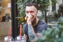 Young male hipster laughing at sidewalk cafe, Shanghai French Concession, Shanghai, China — Stock Photo