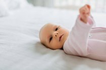 Portrait de bébé fille couchée sur le lit — Photo de stock