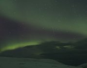Aurora borealis sobre el paisaje cubierto de nieve por la noche, Finnmark, Noruega - foto de stock