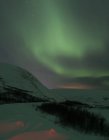 Aurora borealis над заснеженными шипами ночью, Омарк, Норвегия — стоковое фото
