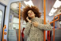 Woman using mobile phone in train — Stock Photo