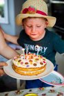 Boy blowing out candles on birthday cake — Stock Photo