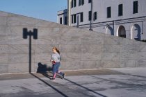 Corredor femenino joven curvilíneo corriendo por la acera - foto de stock