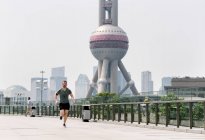 Jeune homme courir dans Shanghai centre financier, Shanghai, Chine — Photo de stock