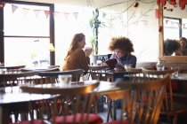 Дві молоді жінки розслабляються в кафе — стокове фото