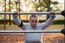 Kurvenreiche junge Frau lehnt im Park an Geländer — Stockfoto