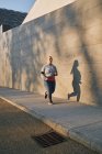 Kurvenreiche junge Frau läuft auf Gehweg — Stockfoto