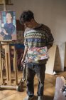 Junge Künstlerin mit Palette im Atelier — Stockfoto