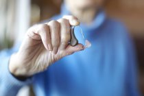 Senior woman holding hearing aid, close-up — Stock Photo