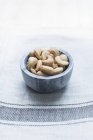 Закрыть орехи кешью в миске на скатерти — стоковое фото