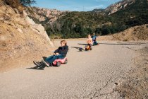 Троє дітей, спускаються вниз іграшкові автомобілі — стокове фото