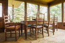 Обеденный стол и стулья, обработанные деревянные полы внутри загородного дома, Квебек, Канада — стоковое фото