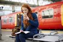 Woman on bench in train station platform — Stock Photo
