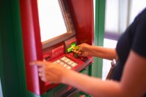 Ausgeschnittene Ansicht einer Frau, die Geld am Geldautomaten abhebt — Stockfoto