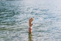 Молодая женщина в бикини по колено в озере Комо, Ломбардия, Италия — стоковое фото