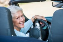 Retrato de mulher idosa em carro conversível — Fotografia de Stock