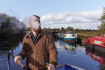 Man smoking electronic cigarette on canal boat — Stock Photo