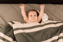Портрет девочки, лежащей в постели с мягкой игрушкой — стоковое фото