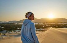 Mujer mirando al atardecer sobre dunas, Florianópolis, Santa Catarina, Brasil, América del Sur - foto de stock