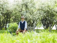 Agricoltore seduto sul carrello delle piante in campo — Foto stock