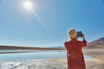 Frau fotografiert Landschaft mit digitalem Tablet, Salar de Chalviri, Chalviri, Oruro, Bolivien, Südamerika — Stockfoto