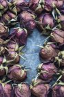 Vue de dessus des bourgeons de roses séchées disposés sur la table — Photo de stock