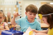 Grundschüler und Mädchen beim Reagenzglasexperiment im Klassenzimmer — Stockfoto