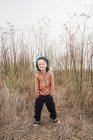 Retrato de niño con las manos en los bolsillos en el entorno rural - foto de stock