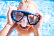 Портрет хлопчика в окулярах для плавання дивиться на камеру посміхаючись — стокове фото