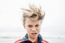 Portrait de garçon aux cheveux salissants sur la plage — Photo de stock