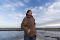 Молода жінка стоїть на пляжному причалі — стокове фото
