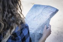 Cropped view of woman looking at folding map — Stock Photo