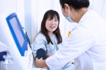 Médico comprobar la presión arterial de los pacientes - foto de stock