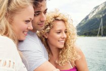 Friends huddled together smiling, looking away — Stock Photo