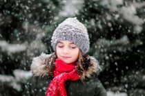 Retrato de menina com os olhos fechados na neve caindo — Fotografia de Stock
