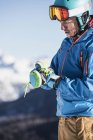 Hombre maduro en ropa de esquí poniéndose guantes de esquí - foto de stock