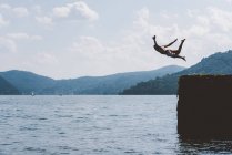 Giovane nuotatore di sesso maschile che si tuffa dal molo, Lago di Como, Lombardia, Italia — Foto stock