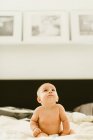 Mignon bébé fille regardant vers le haut sur le lit — Photo de stock