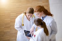 Три жінки-лікарі дивляться на цифровий планшет — стокове фото