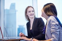 Colleagues using laptop laughing — Stock Photo