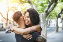 Multi ethnic hipster couple hugging on street, Shanghai French Concession, Shanghai, China — Stock Photo