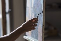 Artista masculino pintando sobre lienzo en estudio - foto de stock