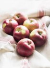Seis manzanas rojas en tela de cocina - foto de stock