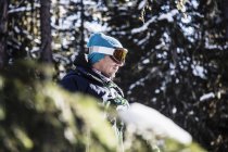 Retrato de esquiador ao lado de árvores olhando para a vista — Fotografia de Stock