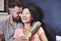 Multi ethnic hipster couple in cafe laughing, Shanghai French Concession, Shanghai, China — Stock Photo