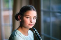 Portrait of girl with clarinet looking at camera — Stock Photo