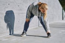 Kurvenreiche junge Frau trainiert und berührt Zehen — Stockfoto